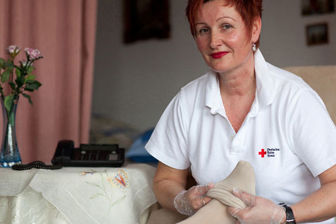 01 Deutsches Rotes Kreuz DRK, Einsatzbereiche / Aktivitaeten / Leistungen / Aufgaben, Sozialarbeit, Ambulante Pflege Hauspflege haeusliche Pflege, Strumpf, anziehen, Einmalhandschuhe, Betreuung