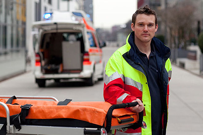 Foto: Einsatzkraft vor Krankenwagen